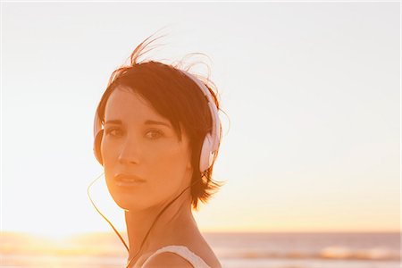 Close up portrait of confident woman wearing headphones at beach Foto de stock - Sin royalties Premium, Código: 6113-06898962