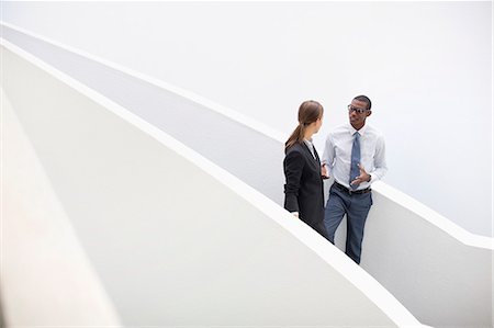 explain to people - Businessman and businesswoman talking on modern staircase Stock Photo - Premium Royalty-Free, Code: 6113-06898993