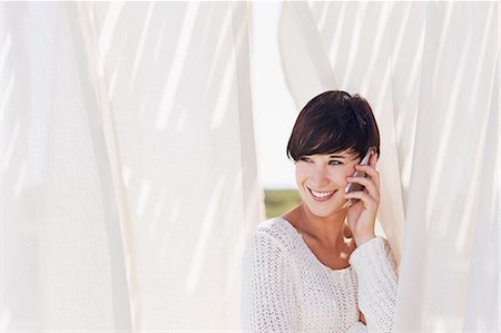 rideau - Smiling woman talking on cell phone Photographie de stock - Premium Libres de Droits, Code: 6113-06898934