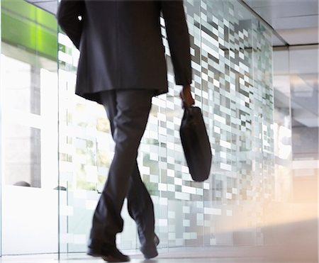 photos of man backside - Businessman with briefcase walking in lobby Stock Photo - Premium Royalty-Free, Code: 6113-06899023