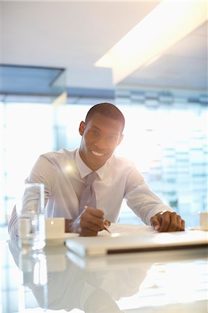 Portrait of smiling businessman working in office Stock Photo - Premium Royalty-Free, Code: 6113-06899035