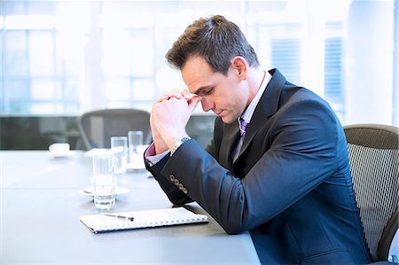 Businessman with head in hands in conference room Stock Photo - Premium Royalty-Free, Code: 6113-06899170