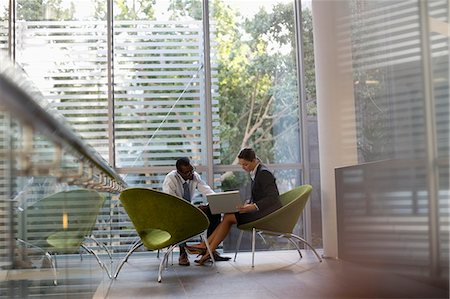 simsearch:6113-06899158,k - Businessman and businesswoman using laptop in lobby Stock Photo - Premium Royalty-Free, Code: 6113-06899103