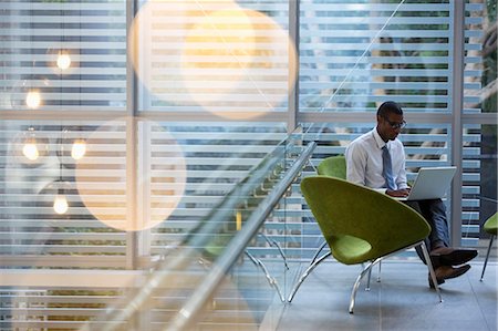 portable computer - Businessman using laptop in lobby Stock Photo - Premium Royalty-Free, Code: 6113-06899108