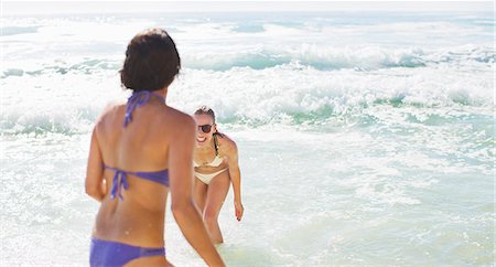 swimsuit teen female - Happy friends in bikinis playing in ocean Stock Photo - Premium Royalty-Free, Code: 6113-06899250