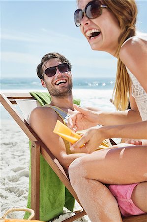 relaxing beach - Happy couple with sunscreen at beach Stock Photo - Premium Royalty-Free, Code: 6113-06899270