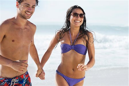 simsearch:6113-06899239,k - Happy couple holding hands and running on beach Stock Photo - Premium Royalty-Free, Code: 6113-06899284