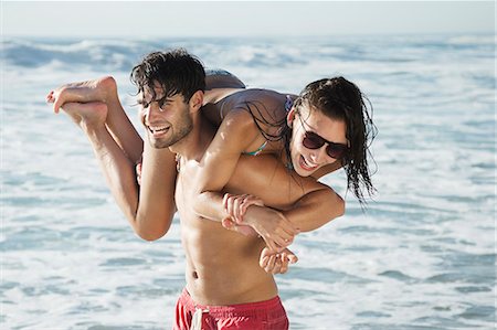 simsearch:6113-06899268,k - Happy man carrying woman on beach Stock Photo - Premium Royalty-Free, Code: 6113-06899291