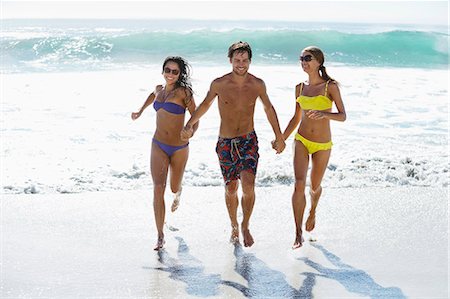 swimwear full body women - Friends holding hands and running on beach Foto de stock - Sin royalties Premium, Código: 6113-06899202