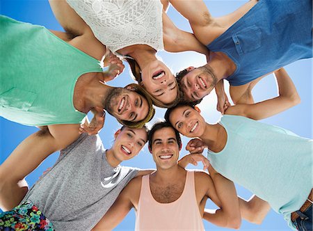 simsearch:6113-06899235,k - Low angle portrait of happy friends in huddle Fotografie stock - Premium Royalty-Free, Codice: 6113-06899209