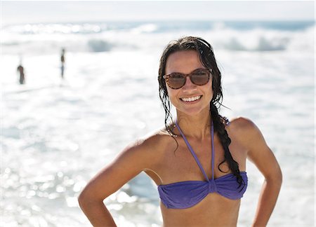 Portrait of smiling woman in bikini and sunglasses at beach Photographie de stock - Premium Libres de Droits, Code: 6113-06899214