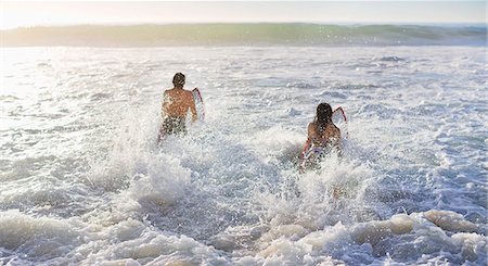 Couple surfing in ocean Stock Photo - Premium Royalty-Free, Code: 6113-06899232