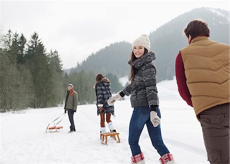 slittino - Friends pulling sleds in snowy field Fotografie stock - Premium Royalty-Free, Codice: 6113-06899340