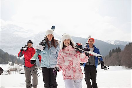 skiing four people - Enthusiastic friends with skis in snowy field Stock Photo - Premium Royalty-Free, Code: 6113-06899385