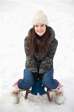 portrait snow - Portrait of smiling woman sitting on sled in snow Stock Photo - Premium Royalty-Free, Code: 6113-06899391
