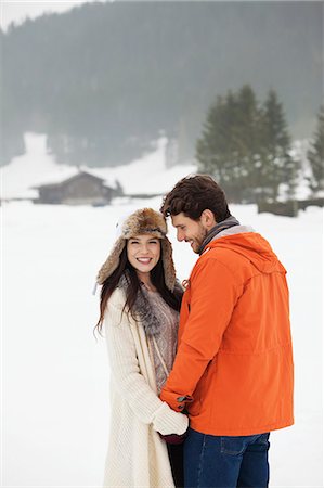 Happy couple holding hands in snowy field Stock Photo - Premium Royalty-Free, Code: 6113-06899326