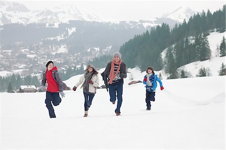 simsearch:6126-09103930,k - Family running in snowy field Foto de stock - Royalty Free Premium, Número: 6113-06899474