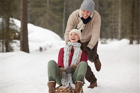 Happy couple sledding in snowy field Stock Photo - Premium Royalty-Free, Code: 6113-06899480