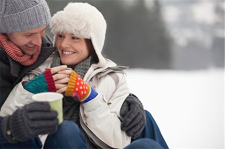 snow couple smiling hugging - Happy couple drinking coffee in snow Stock Photo - Premium Royalty-Free, Code: 6113-06899497