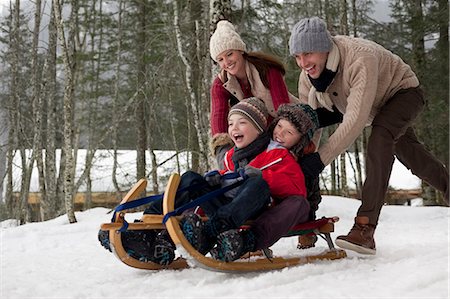 Happy family sledding in snowy woods Foto de stock - Sin royalties Premium, Código: 6113-06899496