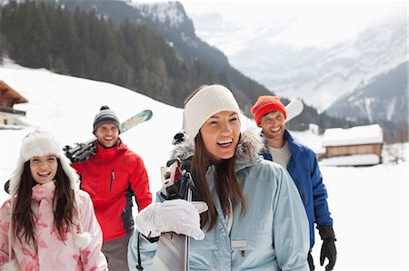 simsearch:6113-06899308,k - Happy friends carrying skis in snowy field Stock Photo - Premium Royalty-Free, Code: 6113-06899402