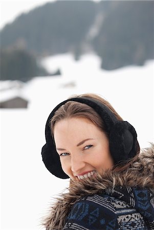 simsearch:6113-06899364,k - Close up portrait of woman wearing earmuffs in snowy field Foto de stock - Sin royalties Premium, Código: 6113-06899409