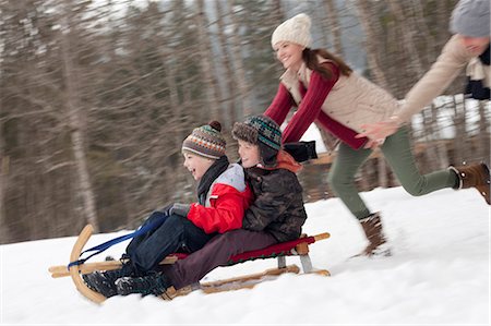 Enthusiastic family sledding in snowy field Foto de stock - Sin royalties Premium, Código: 6113-06899433