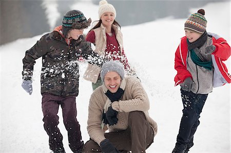 recreational pursuit - Playful family enjoying snowball fight in field Stock Photo - Premium Royalty-Free, Code: 6113-06899436