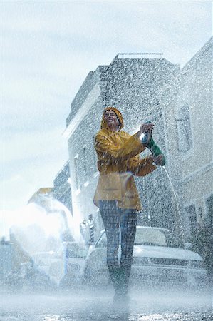 Happy woman walking barefoot in rain Stock Photo - Premium Royalty-Free, Code: 6113-06899541