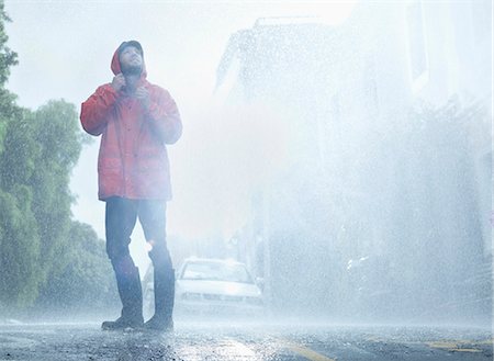 rainy day - Man wearing raincoat in rainy street Foto de stock - Sin royalties Premium, Código: 6113-06899558