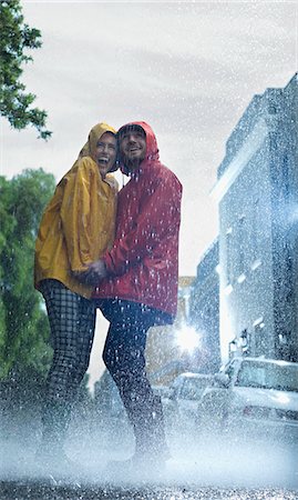 rain wet - Happy couple in raincoats holding hands in rain Stock Photo - Premium Royalty-Free, Code: 6113-06899567