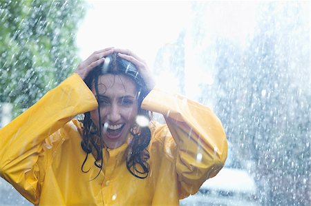 simsearch:6113-06899573,k - Happy woman with hands on head in rain Stock Photo - Premium Royalty-Free, Code: 6113-06899577