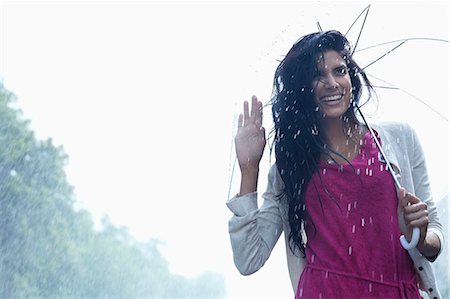 simsearch:6113-06899532,k - Portrait of smiling woman under umbrella in rain Stock Photo - Premium Royalty-Free, Code: 6113-06899594