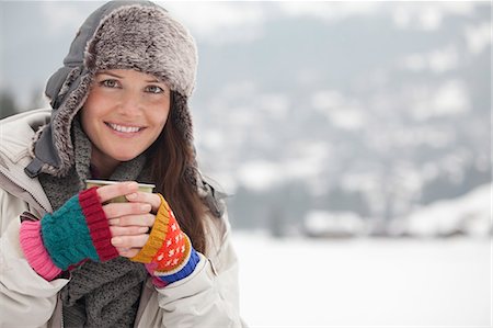 simsearch:6113-06899364,k - Portrait of happy woman in fur hat drinking coffee in snowy field Foto de stock - Sin royalties Premium, Código: 6113-06899518