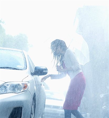 rain - Woman with umbrella reaching for car door handle in rain Stock Photo - Premium Royalty-Free, Code: 6113-06899534