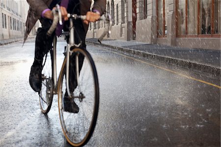 pendeln (pendelverkehr) - Businessman riding bicycle in rainy street Stockbilder - Premium RF Lizenzfrei, Bildnummer: 6113-06899671