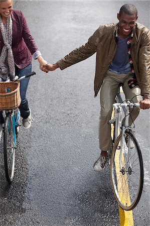 simsearch:6113-07542447,k - Happy couple holding hands and riding bicycles Foto de stock - Sin royalties Premium, Código: 6113-06899674