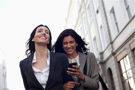 Happy businesswomen text messaging with cell phone Stockbilder - Premium RF Lizenzfrei, Bildnummer: 6113-06899676