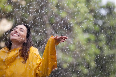 simsearch:6113-06899541,k - Happy woman standing with arms outstretched in rain Photographie de stock - Premium Libres de Droits, Code: 6113-06899602