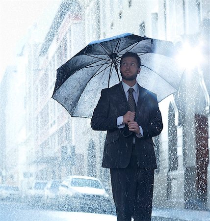 Businessman under umbrella in rainy street Stock Photo - Premium Royalty-Free, Code: 6113-06899604