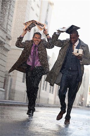 simsearch:6113-06899541,k - Businessmen with coffee covering heads with newspaper in rainy street Photographie de stock - Premium Libres de Droits, Code: 6113-06899622