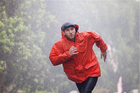 running hat - Man in raincoat running in rain Stock Photo - Premium Royalty-Free, Code: 6113-06899632