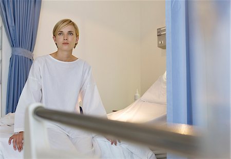 stanza d'ospedale - Patient sitting on hospital bed Fotografie stock - Premium Royalty-Free, Codice: 6113-06908191