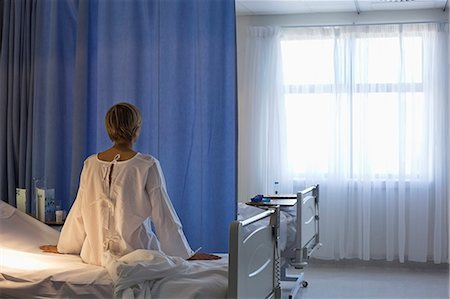 Patient wearing gown on hospital bed Foto de stock - Sin royalties Premium, Código: 6113-06908243