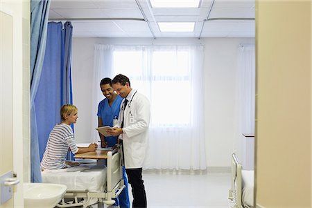 Doctor and nurse talking to patient in hospital room Stock Photo - Premium Royalty-Free, Code: 6113-06908240