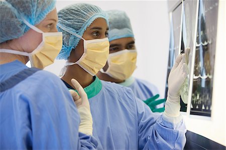 Surgeons examining x-rays in operating room Stock Photo - Premium Royalty-Free, Code: 6113-06908245