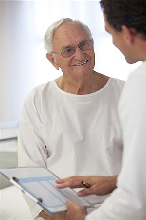 simsearch:6113-07146717,k - Doctor talking with older patient in hospital room Photographie de stock - Premium Libres de Droits, Code: 6113-06908259
