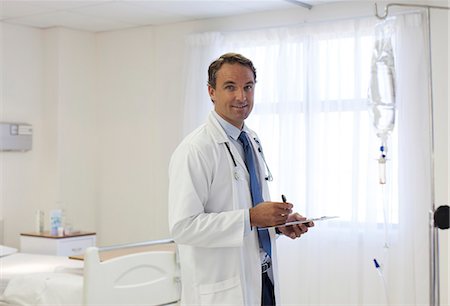 pictures of white men in hospital bed - Doctor writing on clipboard in hospital Stock Photo - Premium Royalty-Free, Code: 6113-06908268