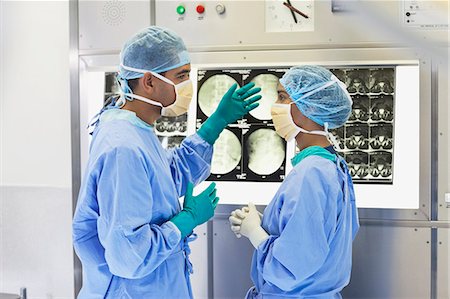 simsearch:6122-07707369,k - Surgeons examining x-rays in hospital Fotografie stock - Premium Royalty-Free, Codice: 6113-06908293