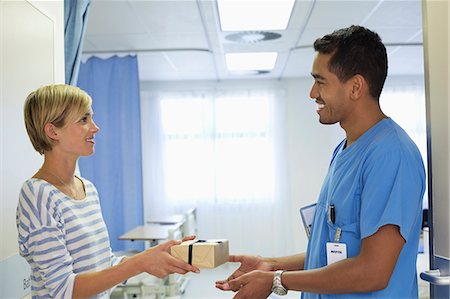 dar - Patient giving nurse gift in hospital Foto de stock - Sin royalties Premium, Código: 6113-06908216